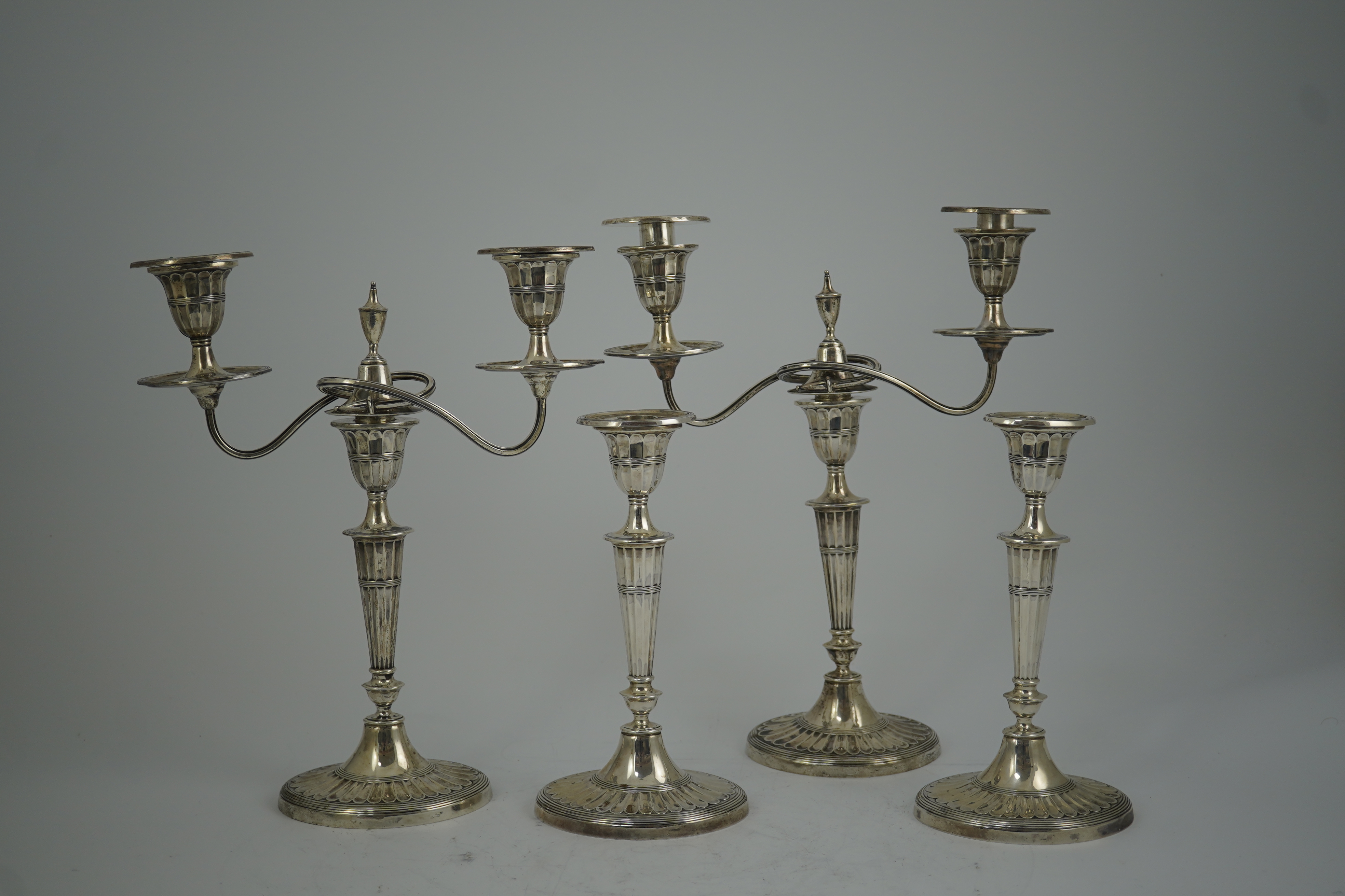 A pair of Edwardian silver two branch, two light candelabra, by Walker & Hall and a pair of matching candlesticks